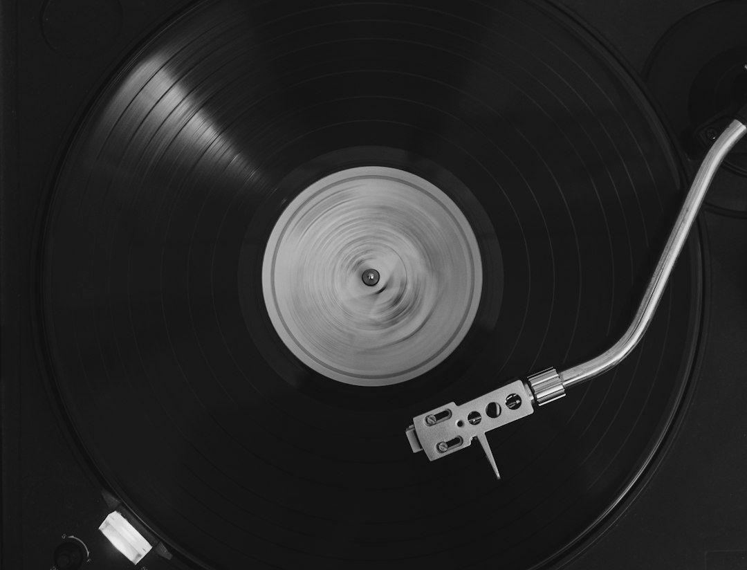 Nahaufnahme eines drehenden Vinyls mit Tonarm auf einem Plattenspieler
